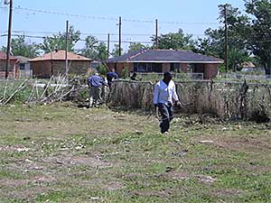 Residents of New Orleans cleaning their backyard following Hurricane Katrina